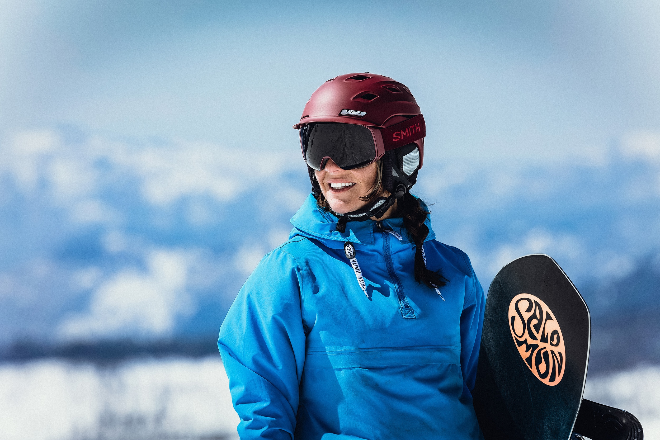 A snowboarder wearing a helmet holding their board