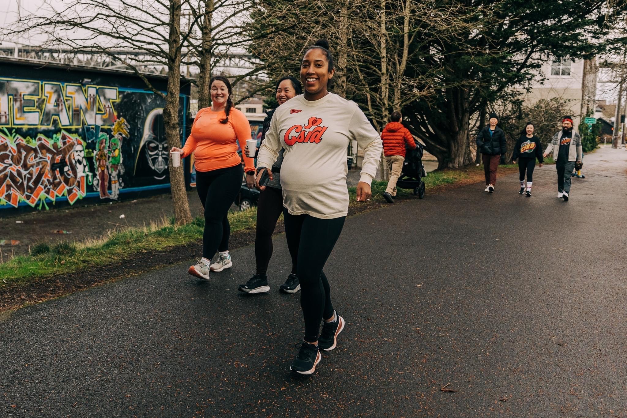 A pregnant woman running with friends in an urban environment