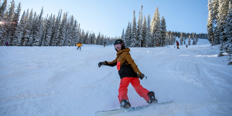 A person snowboards at a ski area