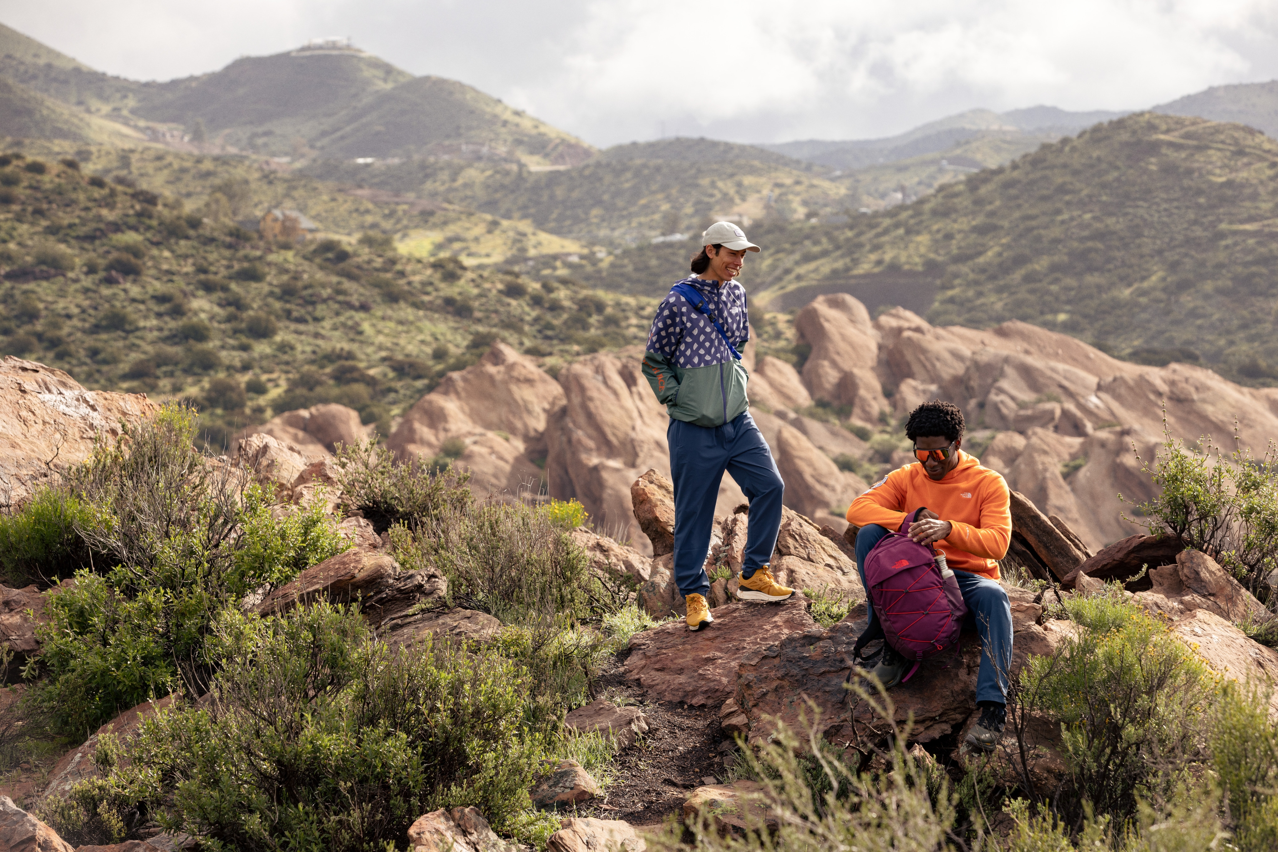 Two hikers rest in a desert landscape