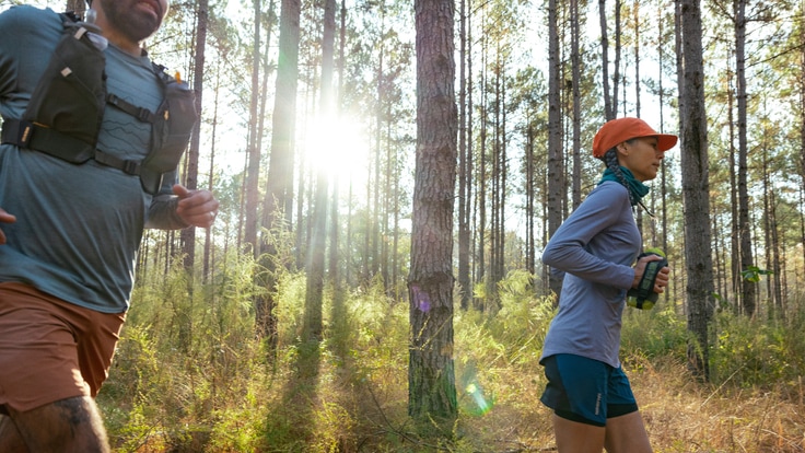 A woman running on a trail in the woods