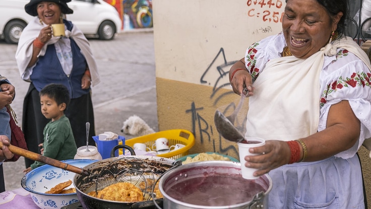 Woman street vendor ladling stew into a cup