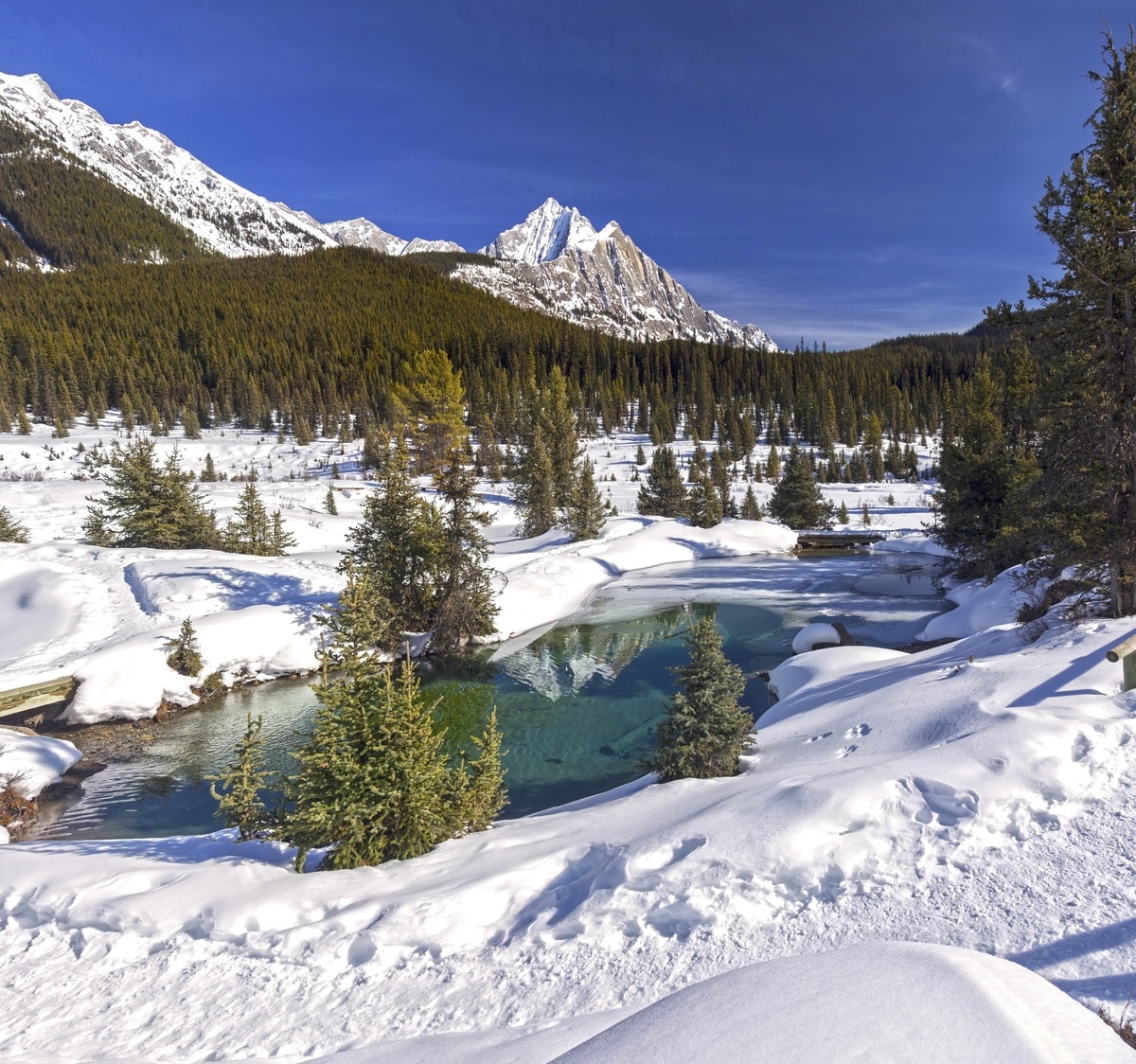 Surrounded by towering peaks, the Ink Pots are a set of geothermal pools which percolate up from deep beneath the snow-covered landscape.