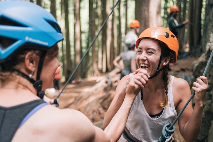 A guide and guest wearing helmets high five each other