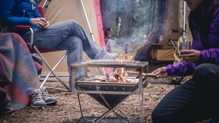 Person feeding a fire at camp