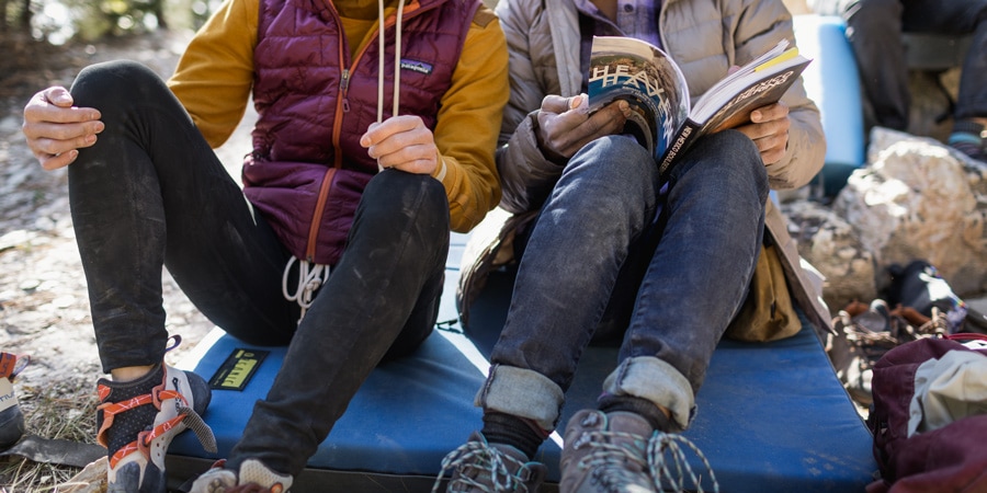 Two climbers looking at a bouldering guidebook.