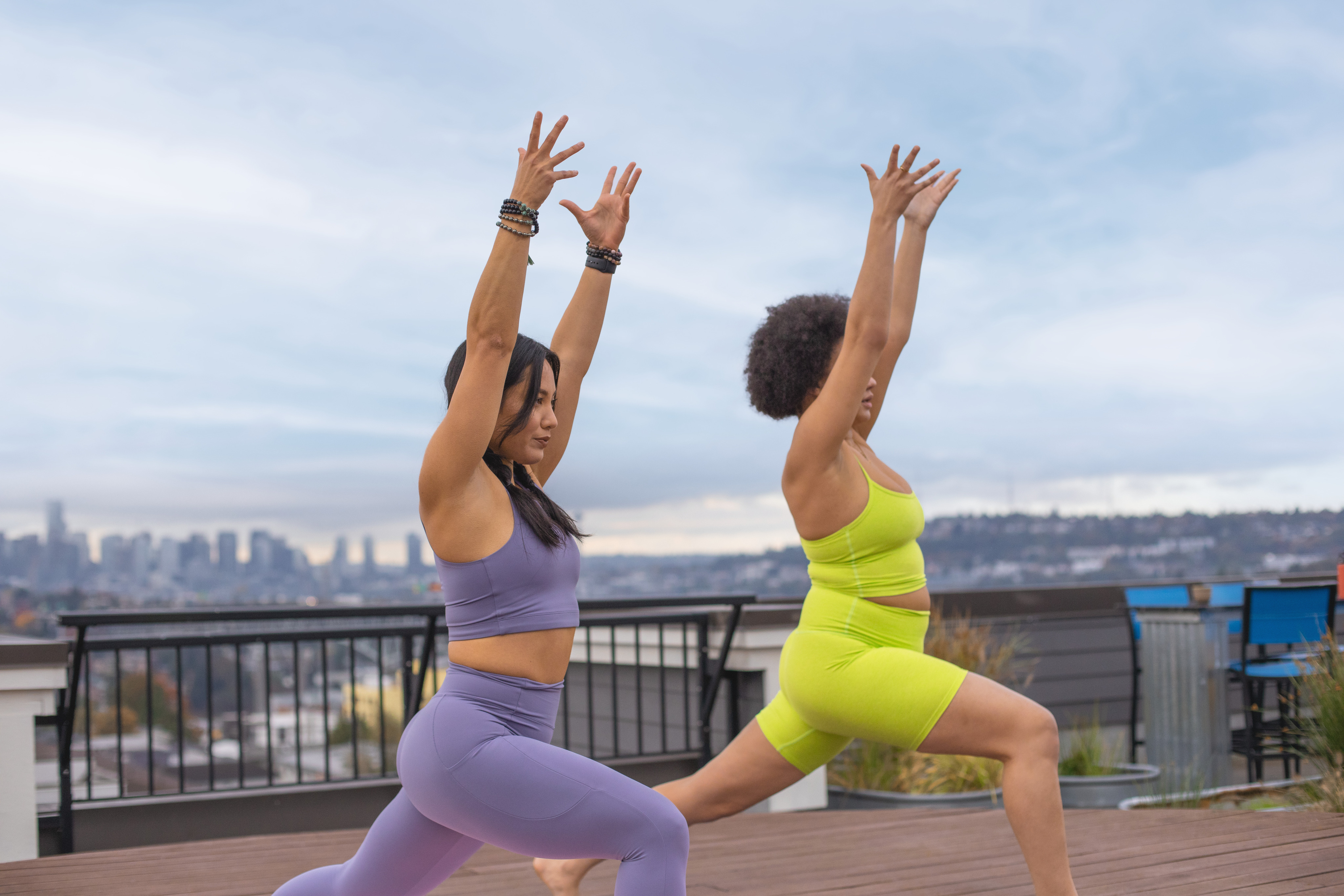 Two people hold a yoga pose.