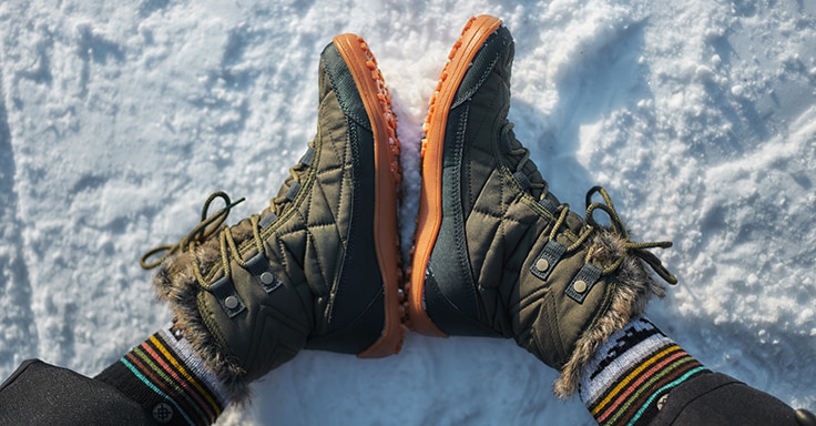 Photo of a person's boots in snow