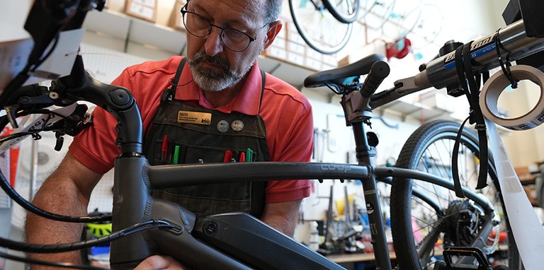 a bike mechanic doing e-bike maintenance in a bike shop