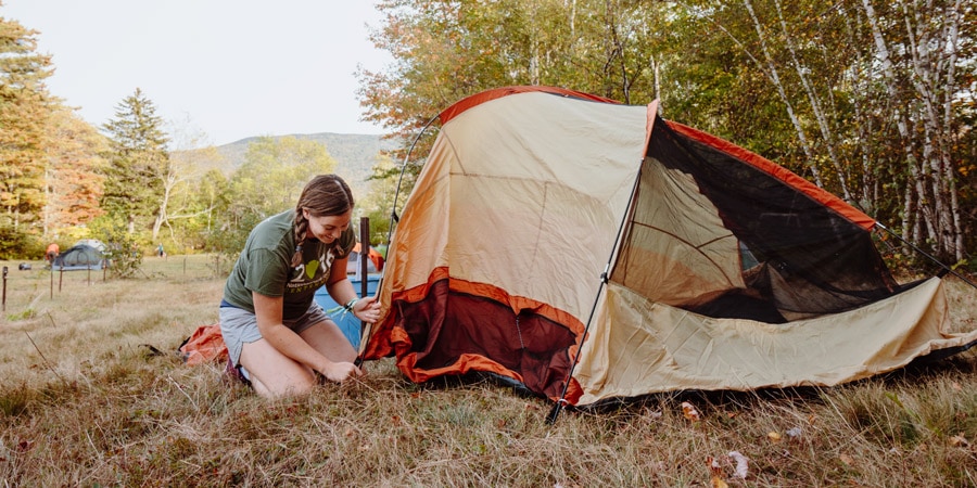 a teen girl pitching her own tent