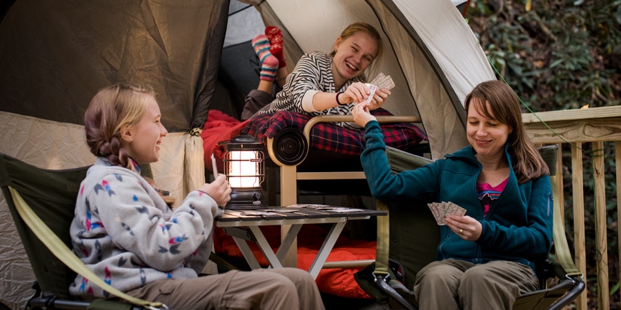 a mom and two daughters playing a fun game of cards