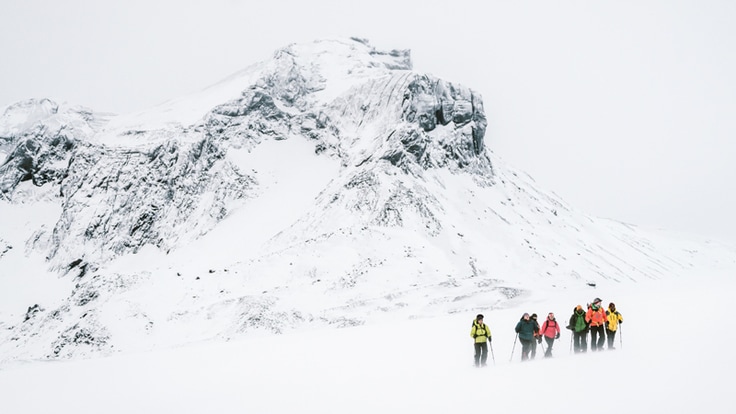 A group of snowshoers walking near mountainous area.