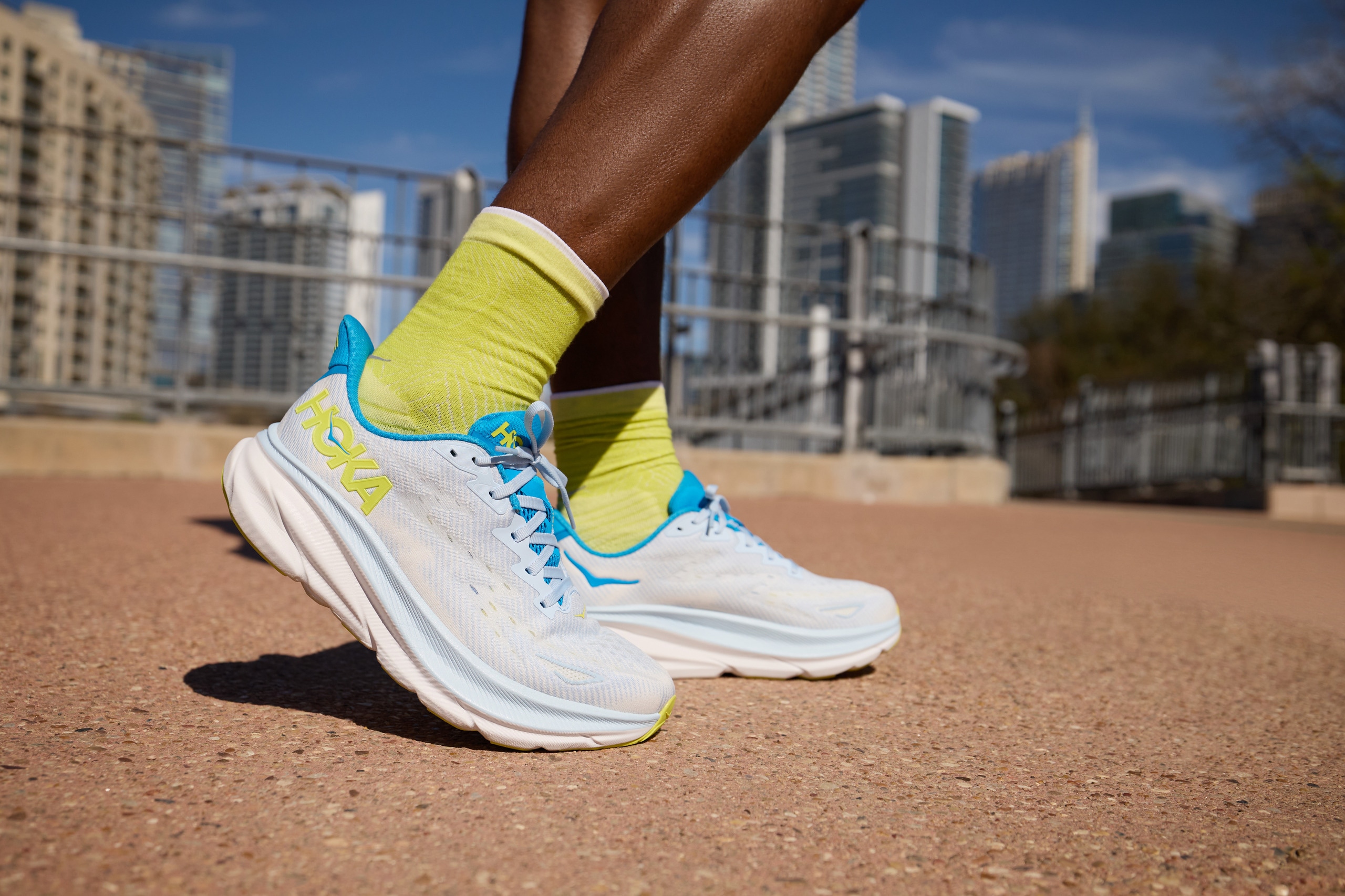 A close-up of a pair of running shoes worn with green socks