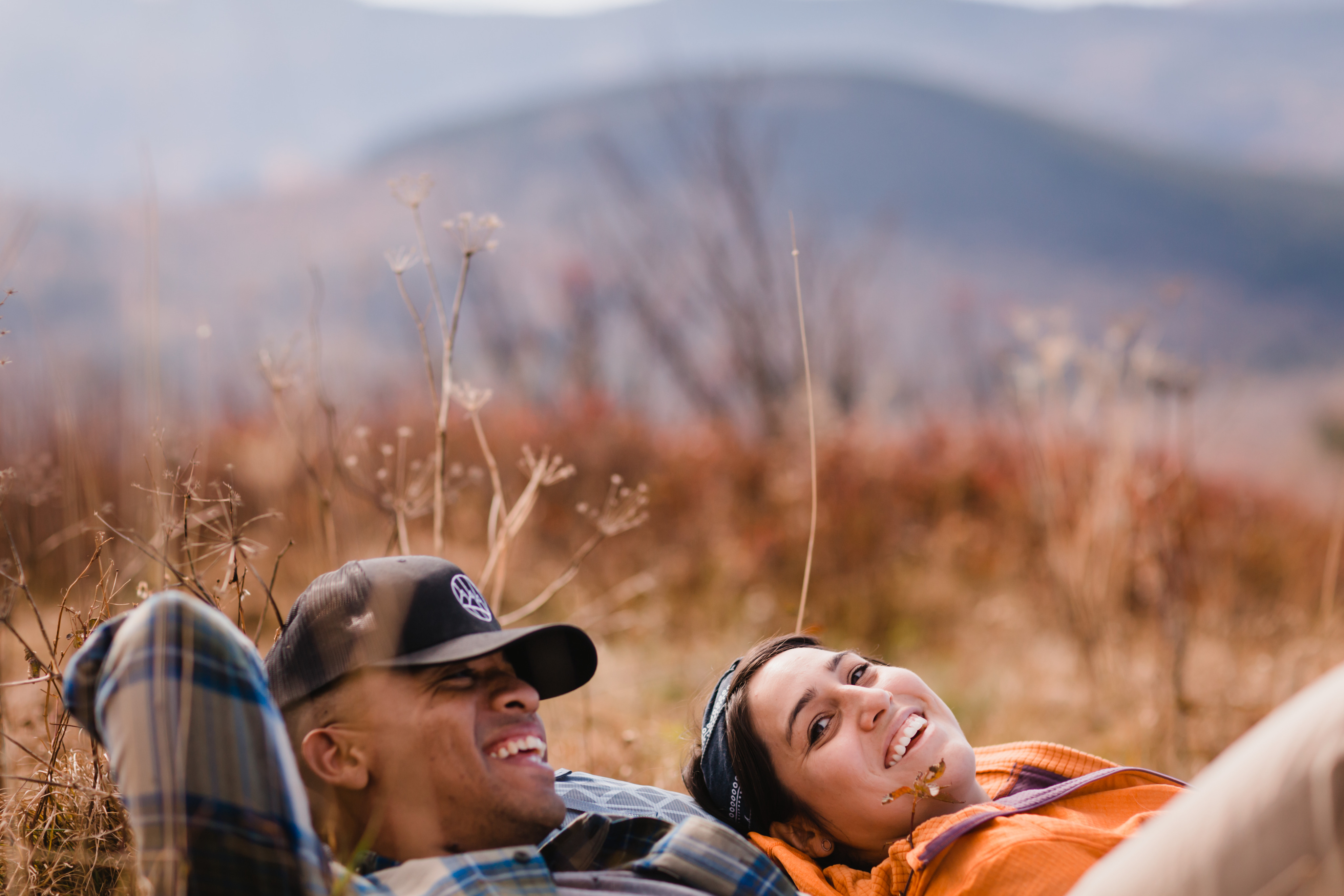 Two people laying in a field enjoying nature