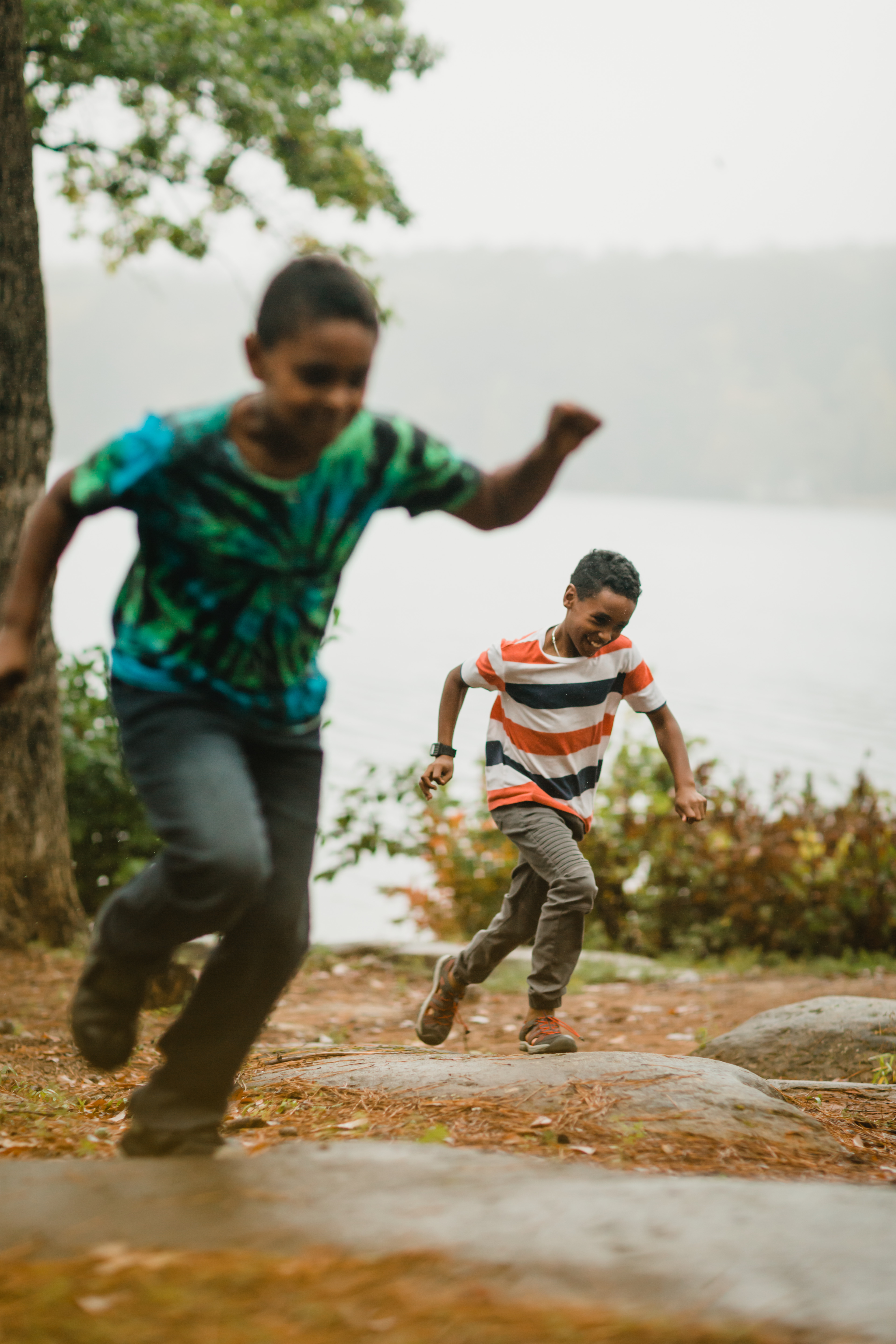 Kids giggle during a foot race through the trees.