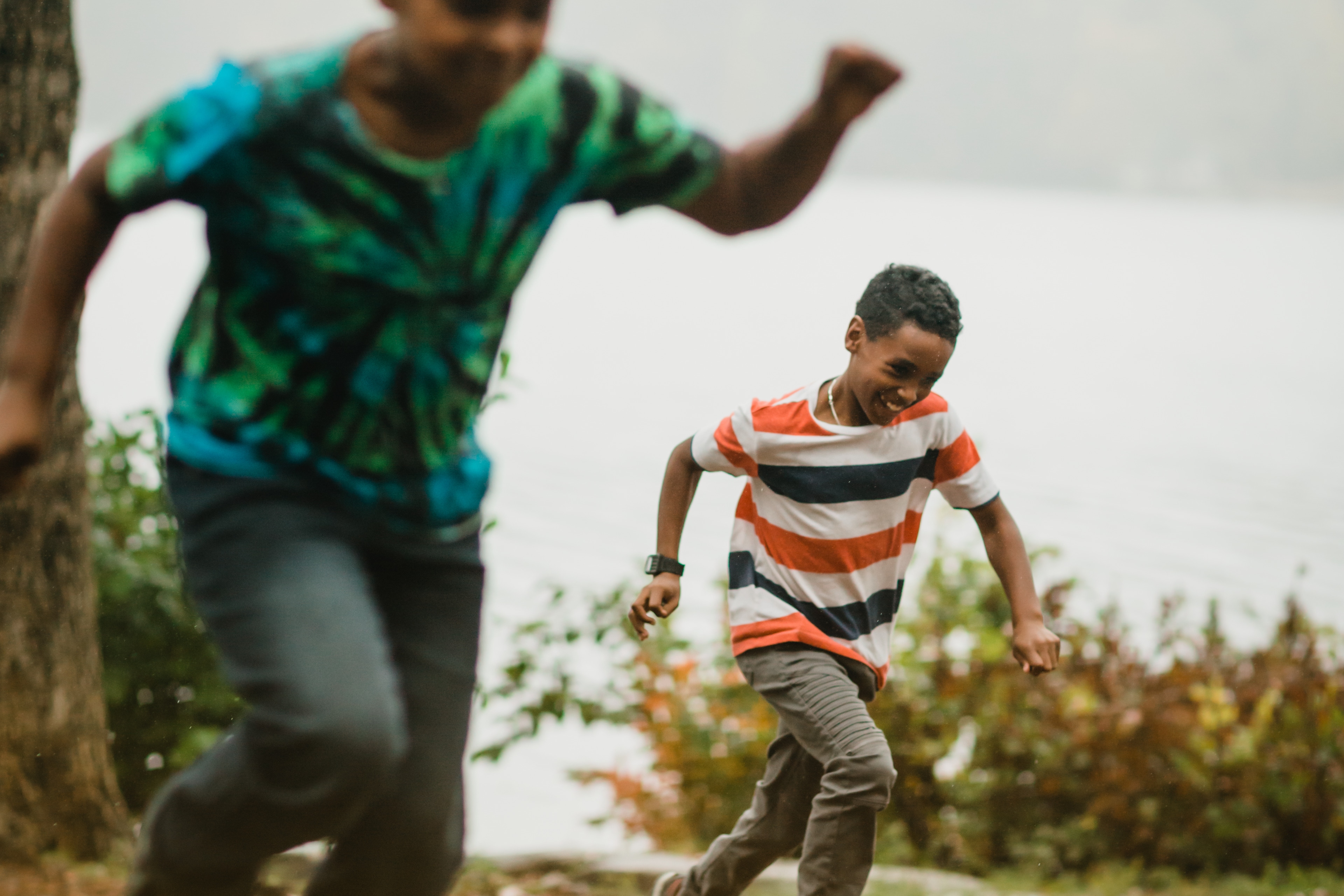 Kids giggle during a foot race through the trees.