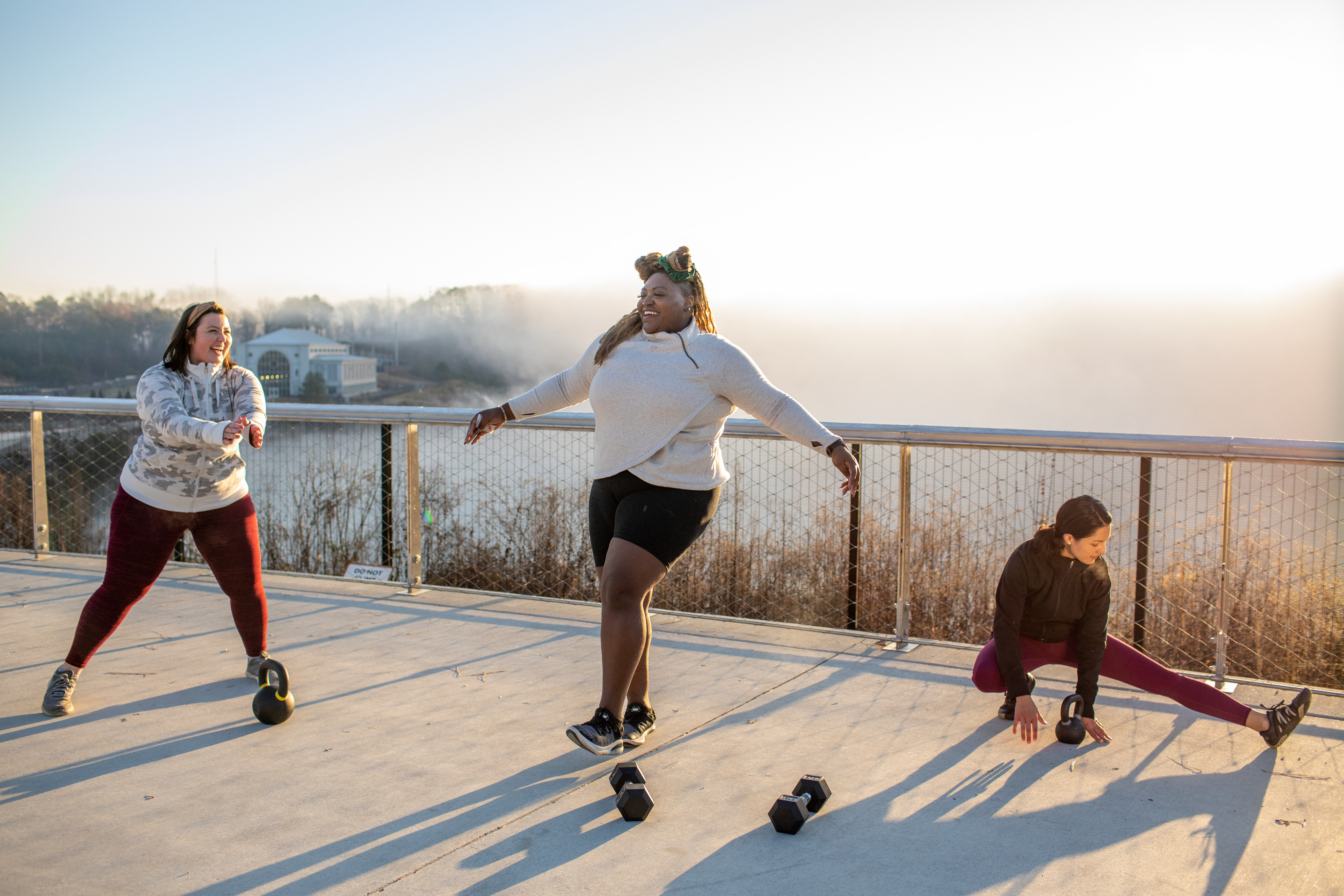 Three women stretch before starting a workout