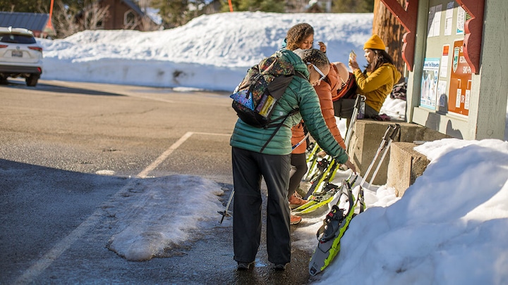 People standing next to snowshoes