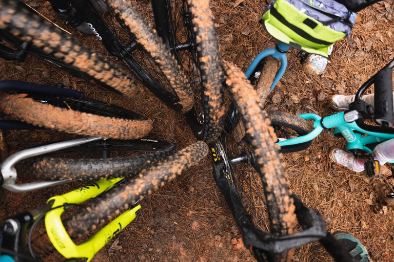 The muddy wheels of nine mountain bikes form a circl