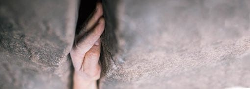 Close up photo of a hand jam in a rock crack