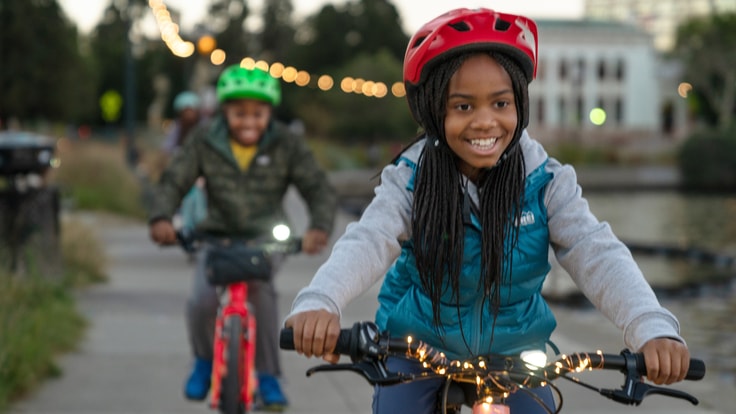 two kids biking on a bike trail