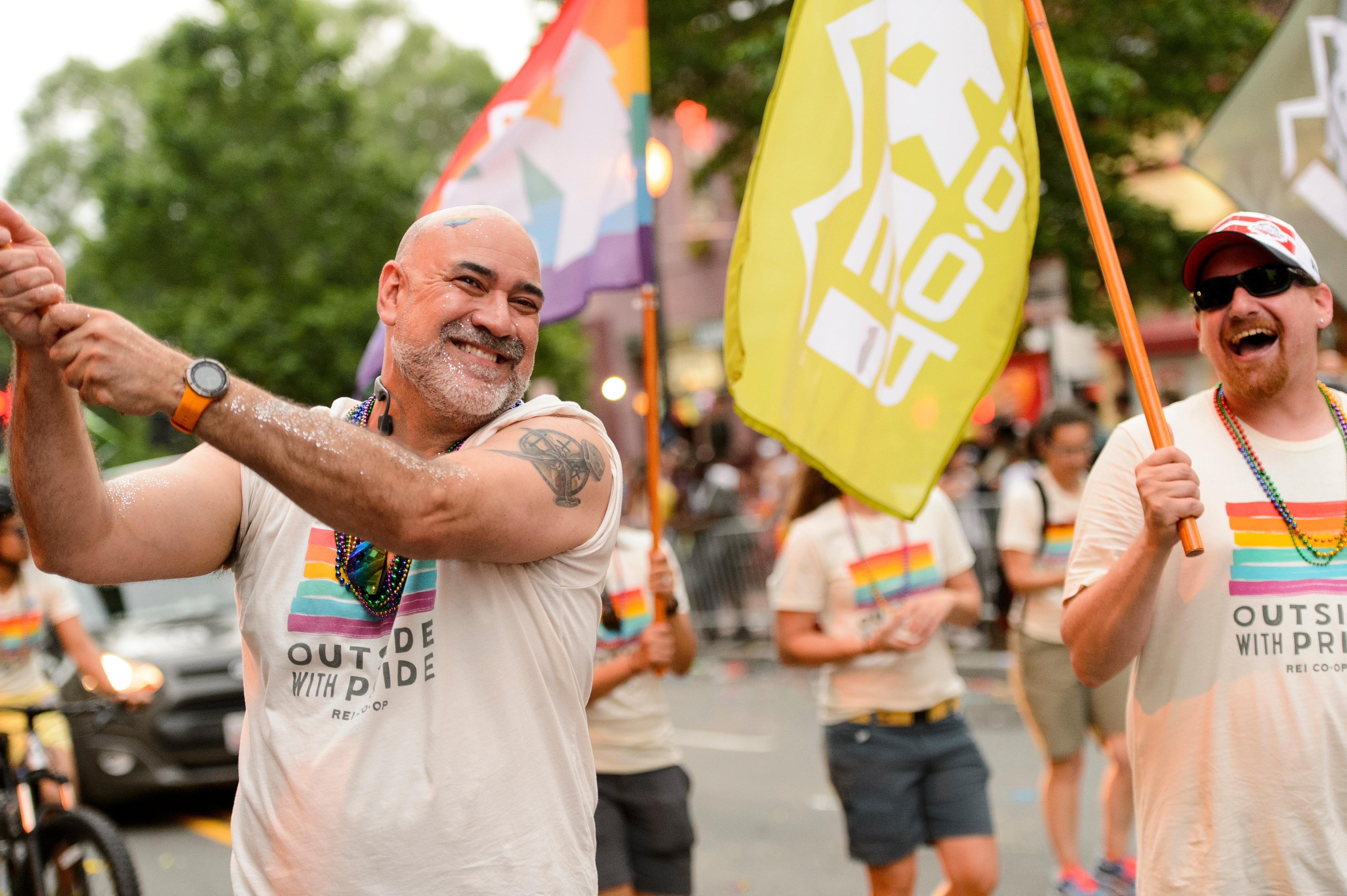 People with signs and flags walking in a Pride parade