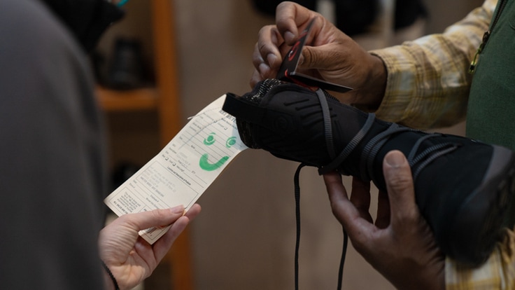 An REI customer inspects the tag on a piece of used gear at REI Co-op.