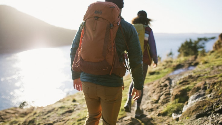 Man and woman hiking at sunset.