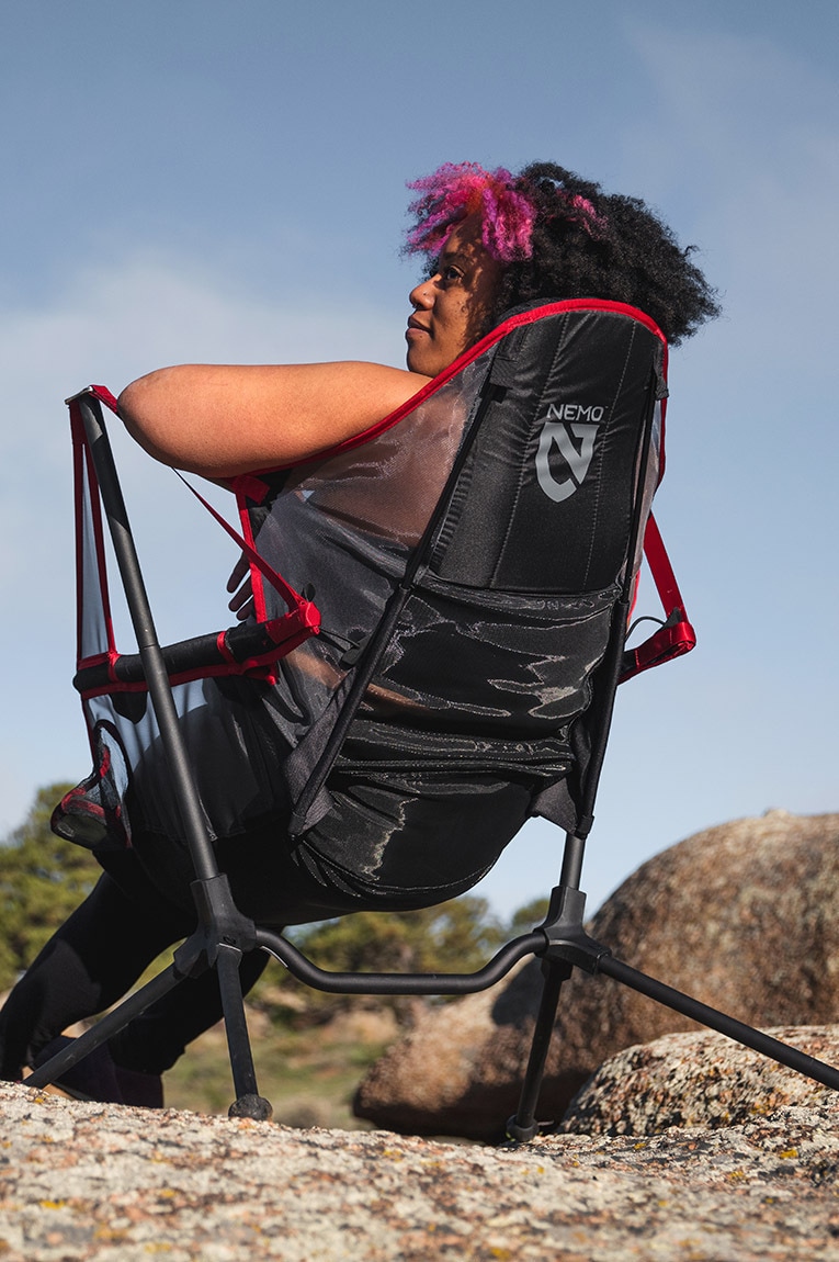 Two campers sit in the Mountain Summit Gear Loveseat.