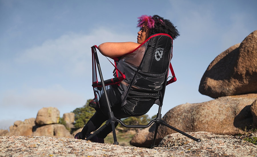 A camper sits in the NEMO Stargaze Recliner Luxury Chair.