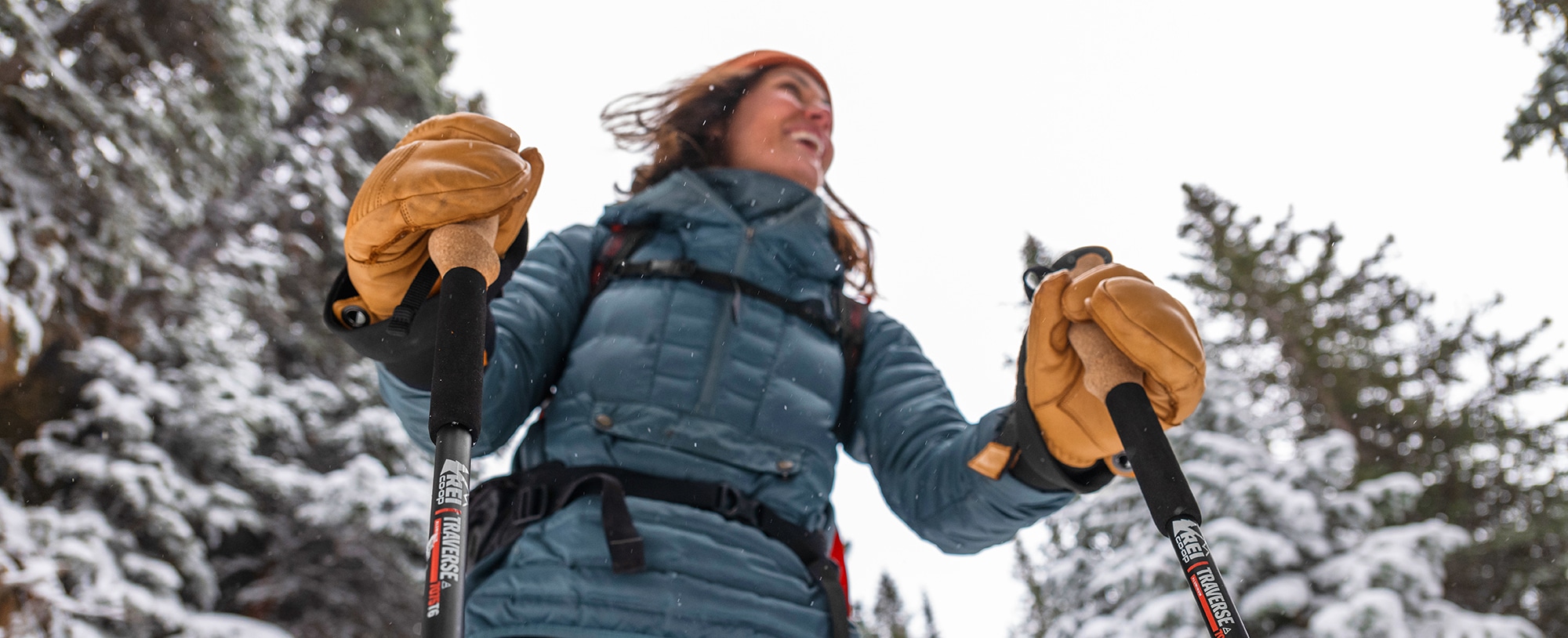 Person with trekking poles in a snowy forest