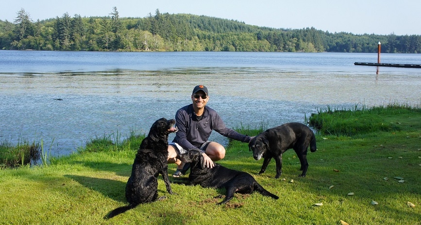 Image of Dan Shull with his three black lab dogs