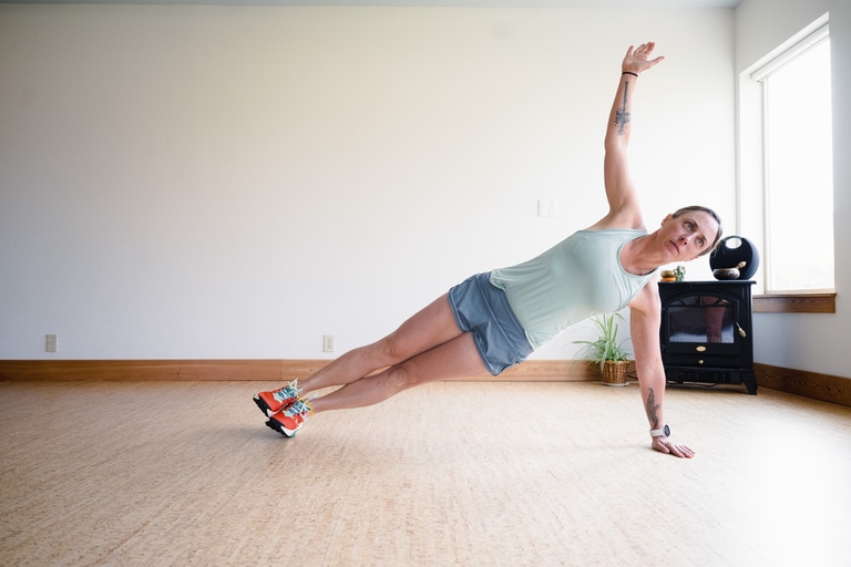 A woman performs a side plank