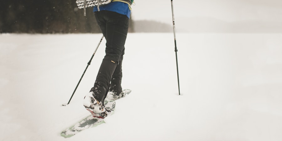 a winter camper snowshoeing in the snow