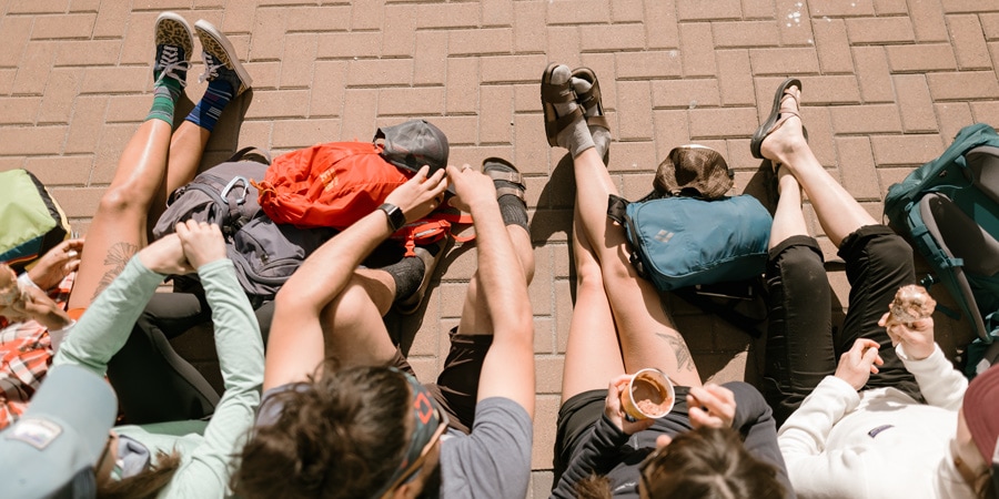 the feet and shoes of a group of travelers