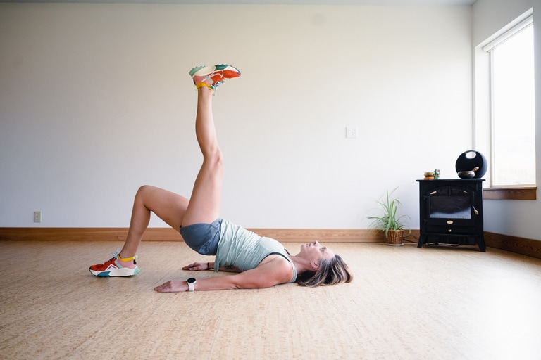 A woman performs a single leg glute bridge