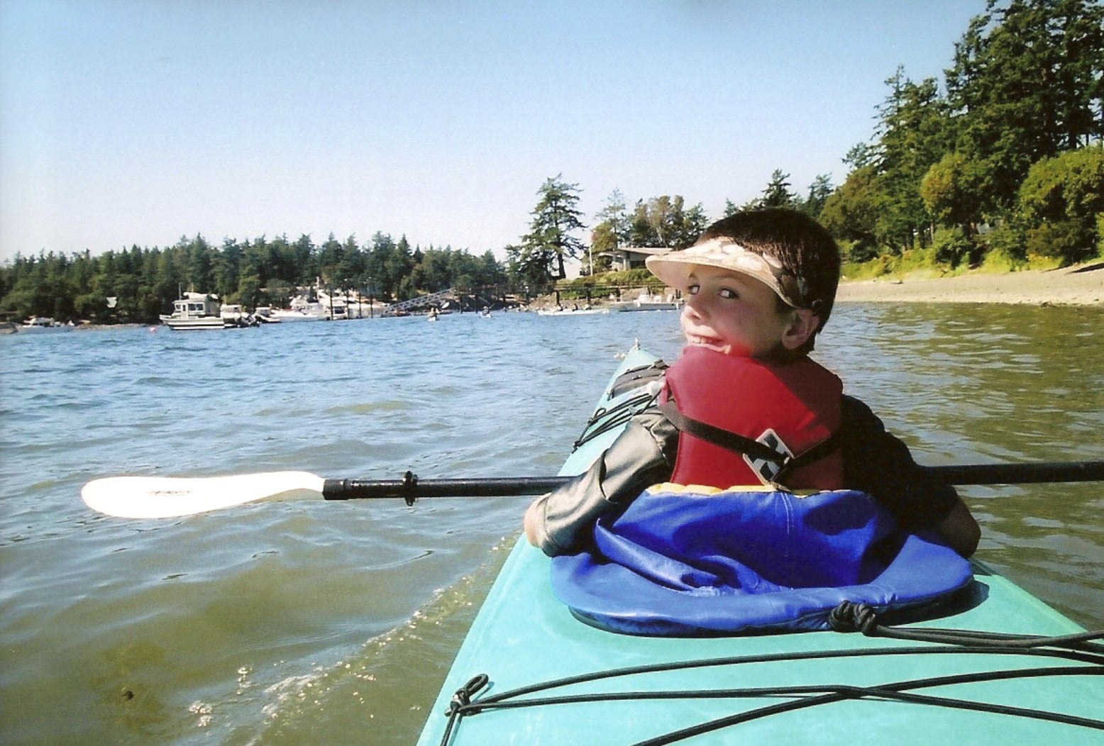 Child sitting in the front seat of a kayak.