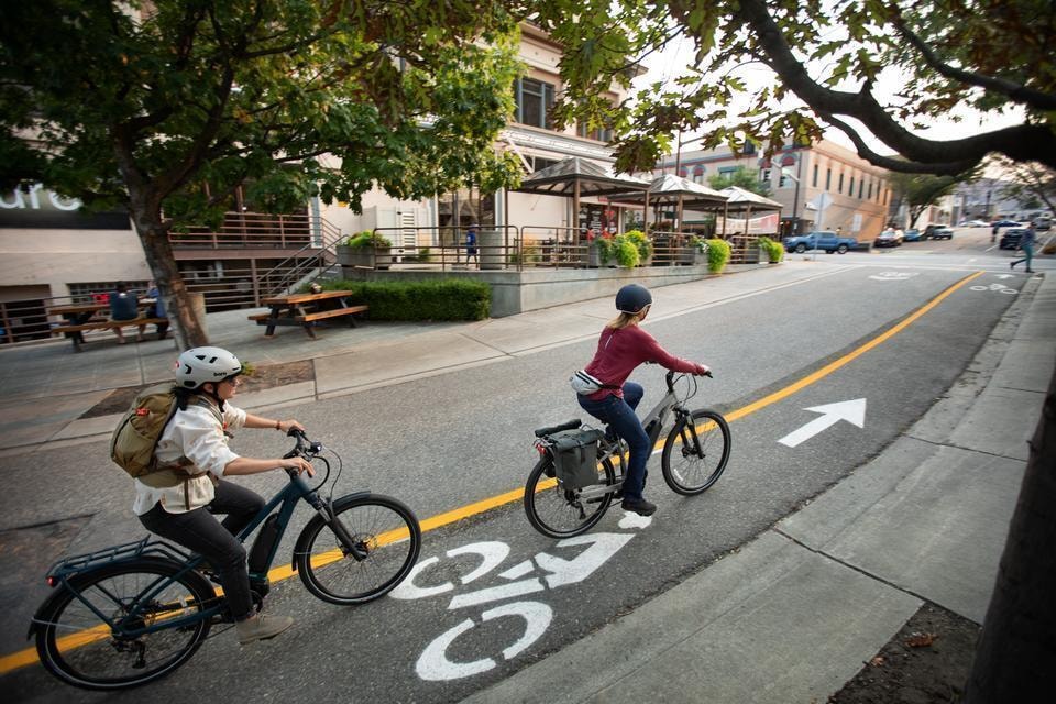 Riding on an e-bike in a city bike lane.