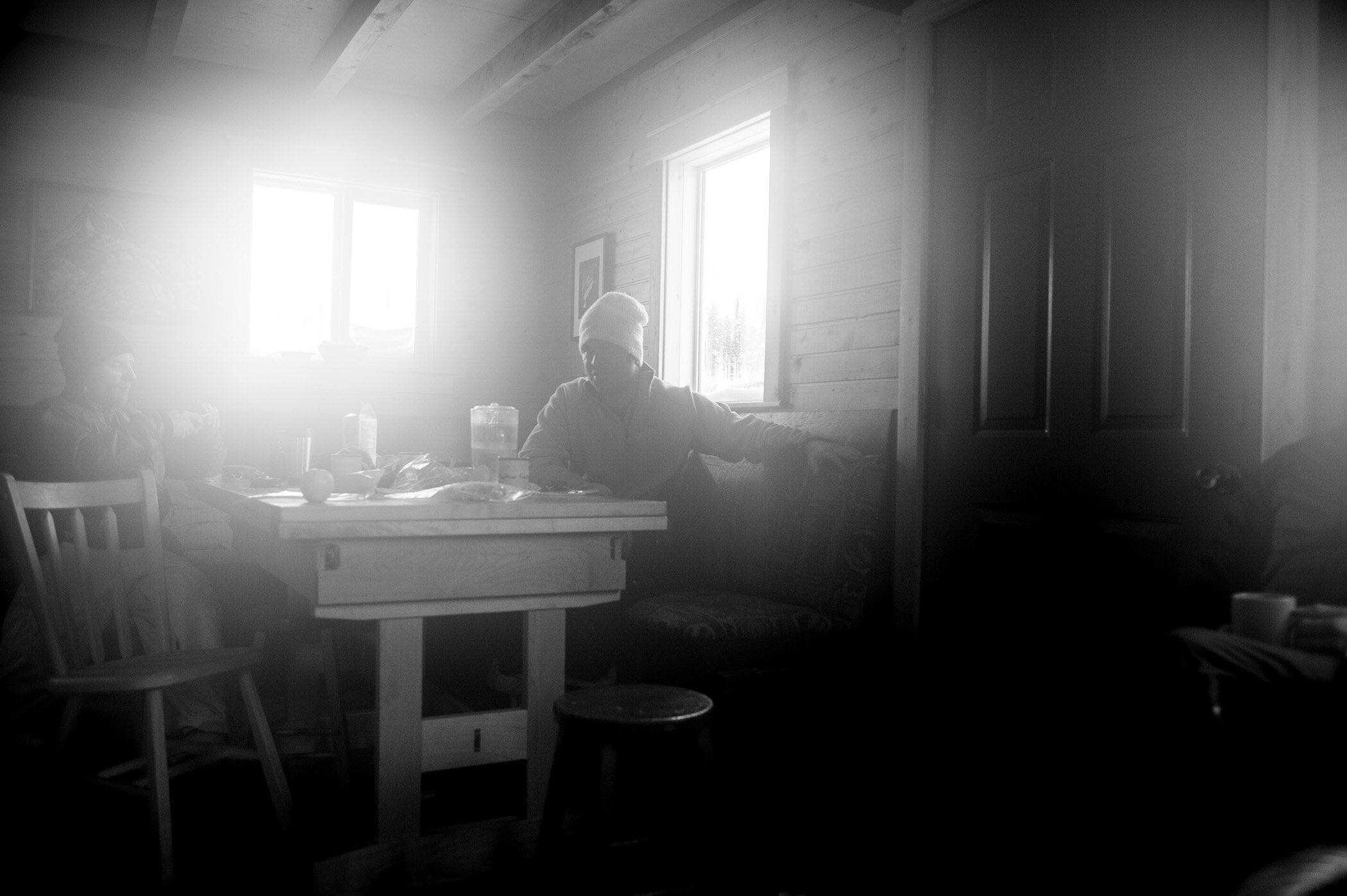 A foggy shot of people sitting a table inside a cabin