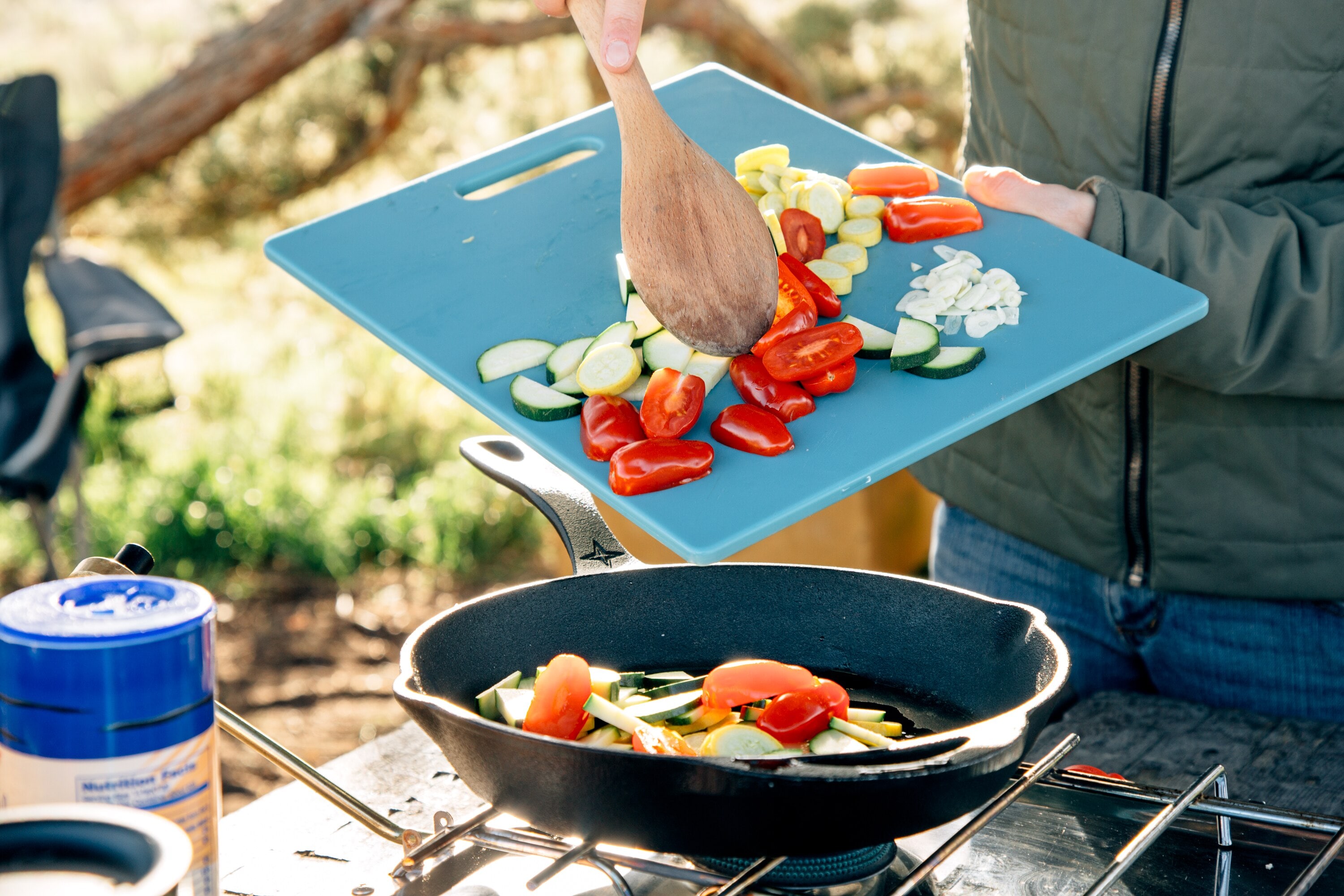 Adding sliced vegetables to skillet