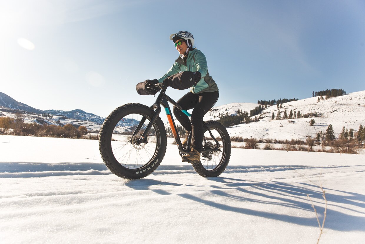 A woman riding a fat bike on a flat trail