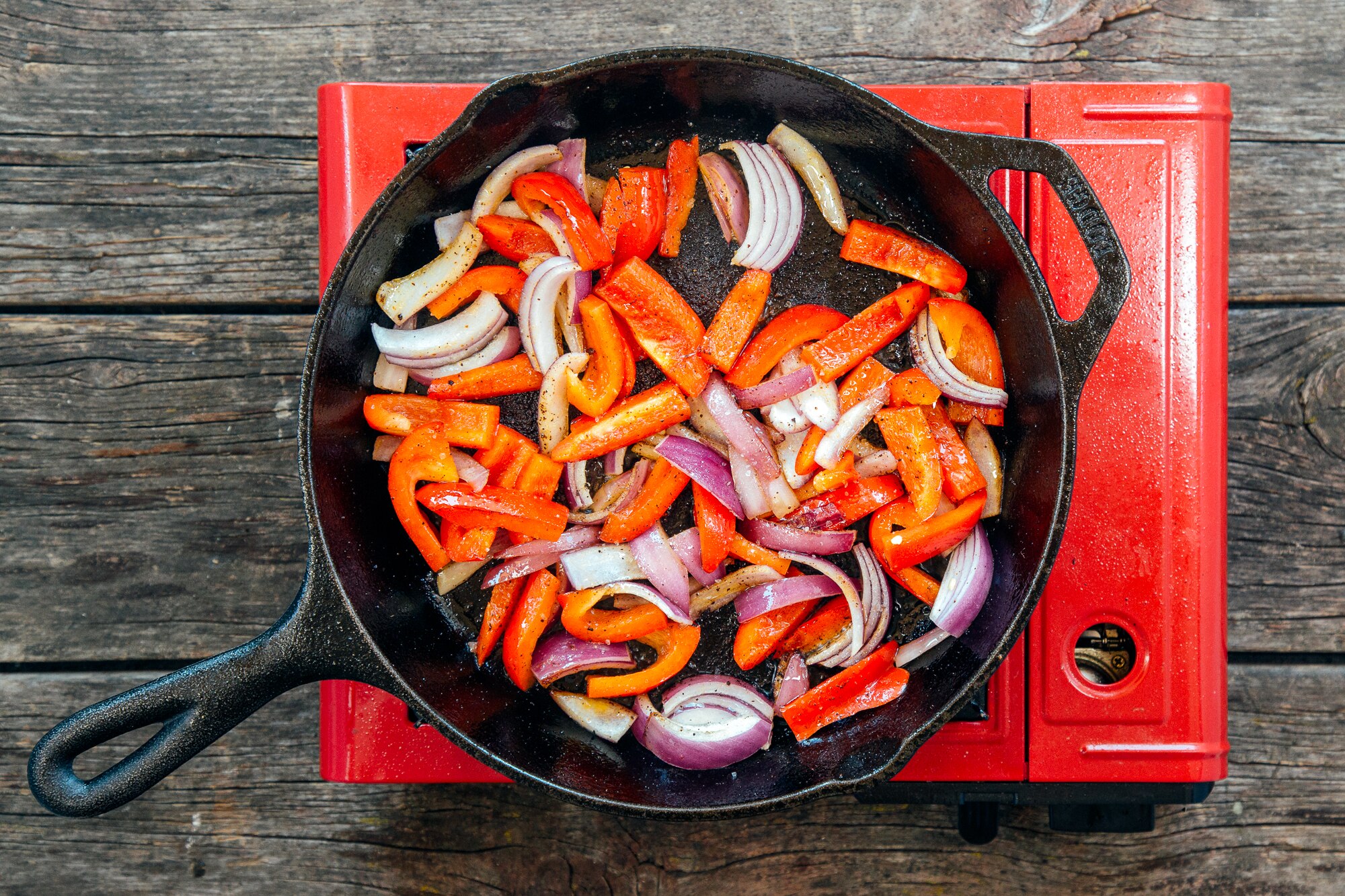 A skillet with vegetables cooking.