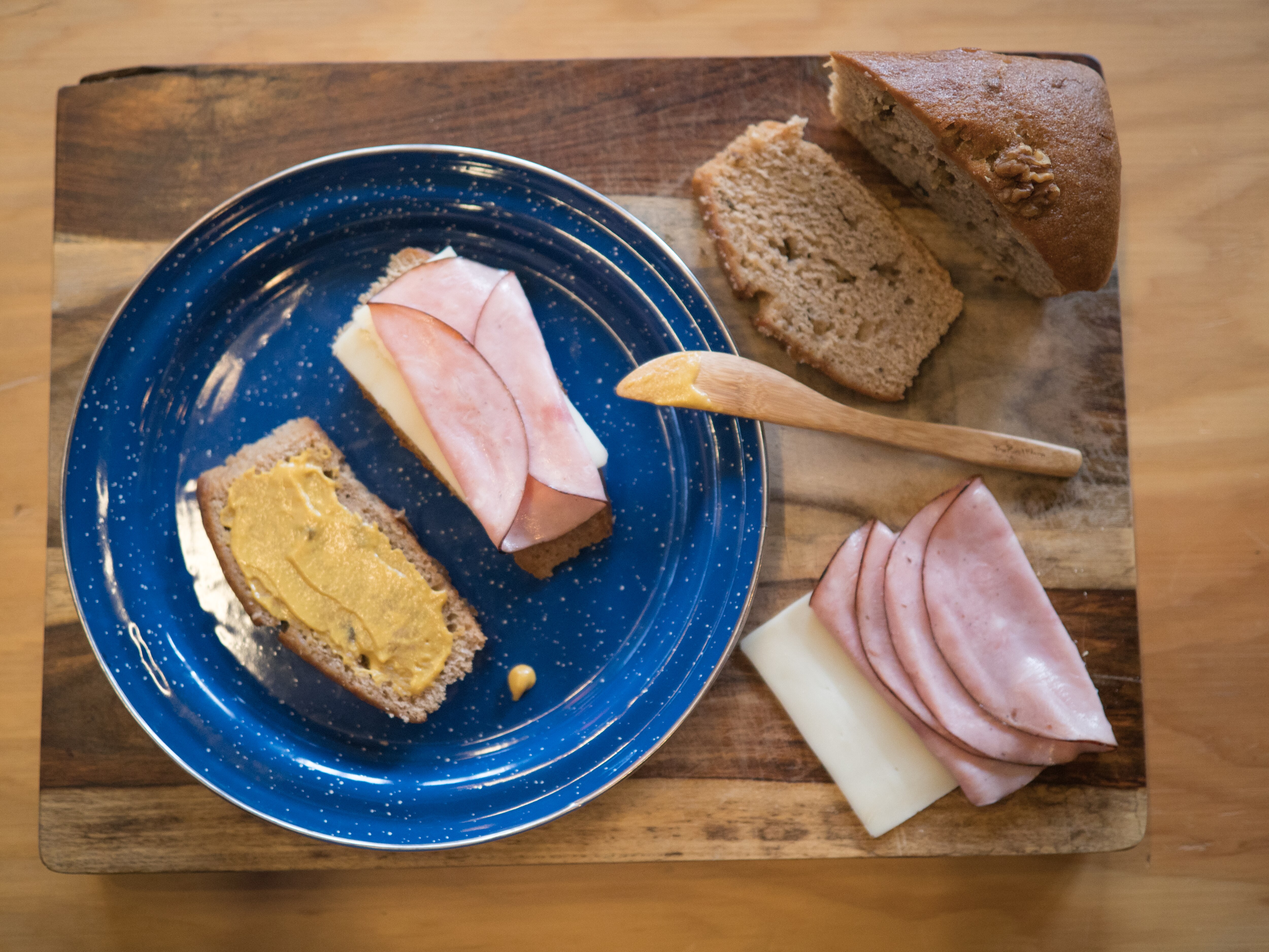 Ham and cheese sandwich makings on a blue plate.