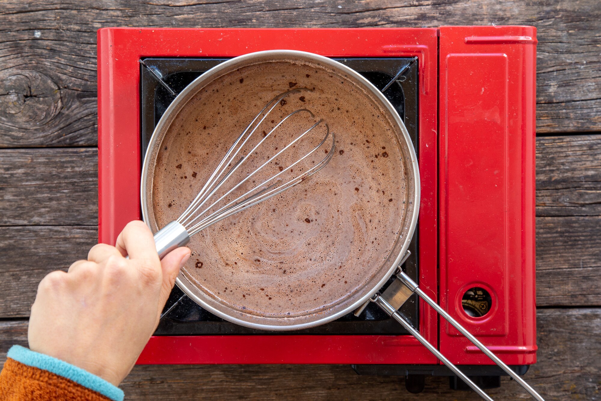 Whisking cocoa into oat milk for coconut hot chocolate