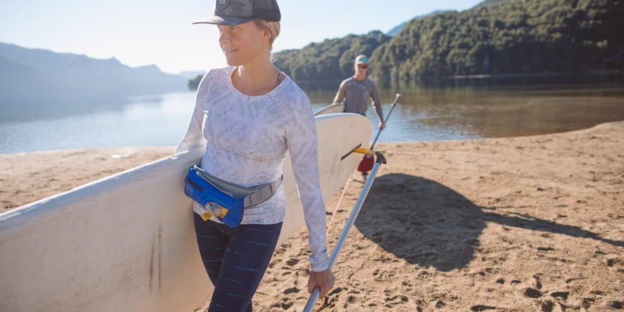 Woman carrying SUP stand up paddle board