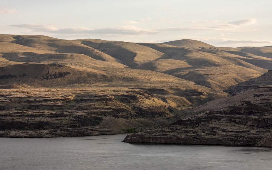 A landscape with rolling hills and a river demonstrates a large depth of field