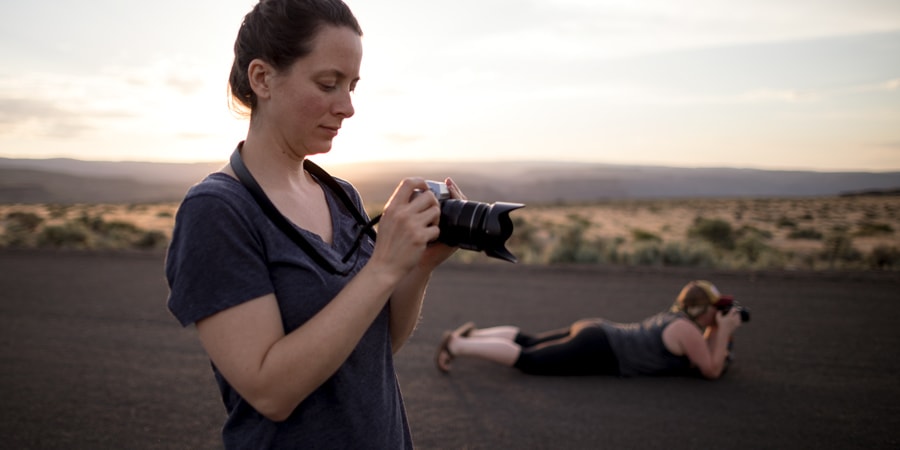 Two women taking photographs in a desert landscape