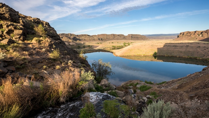 A river feeds into a desert lake under early morning light in Eastern Washington