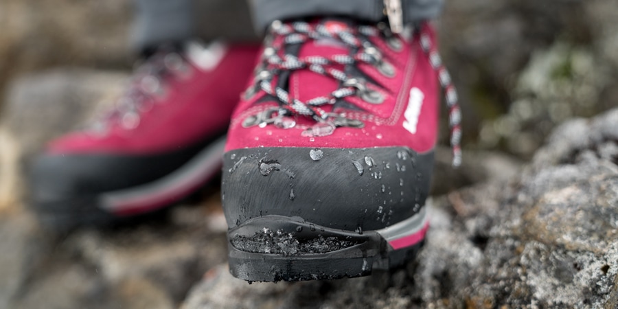 rain droplets repelling off of the toe of a waterproof mountaineering boot