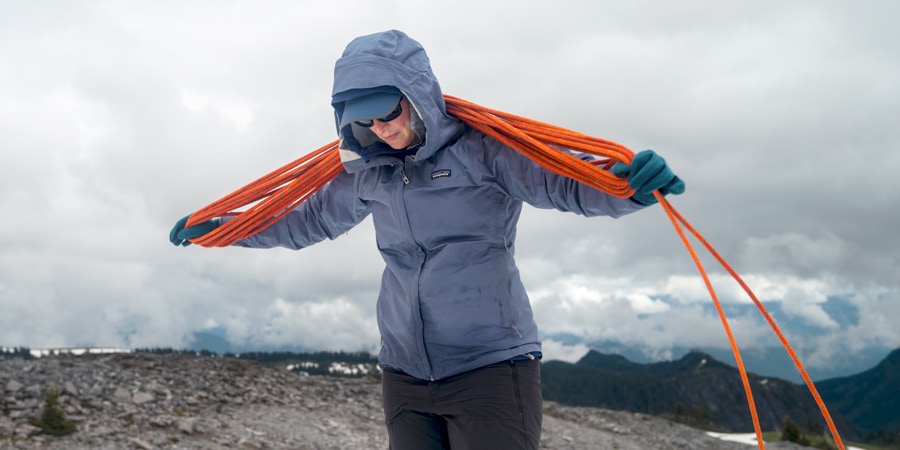 A mountaineer butterfly coils a rope over her neck and shoulders